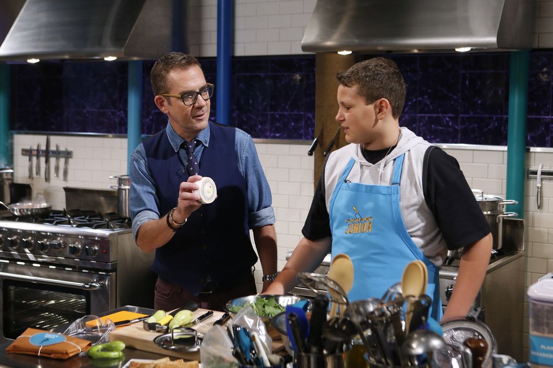 Moderator Ted Allen (l.) ist gespannt, wie sich Micah Riedmann (r.) beim ersten Gang, bei dem die Junior-Köche einen Hammer zum Kochen benutzen müss... - Bildquelle: Jason DeCrow 2015, Television Food Network, G.P. All Rights Reserved