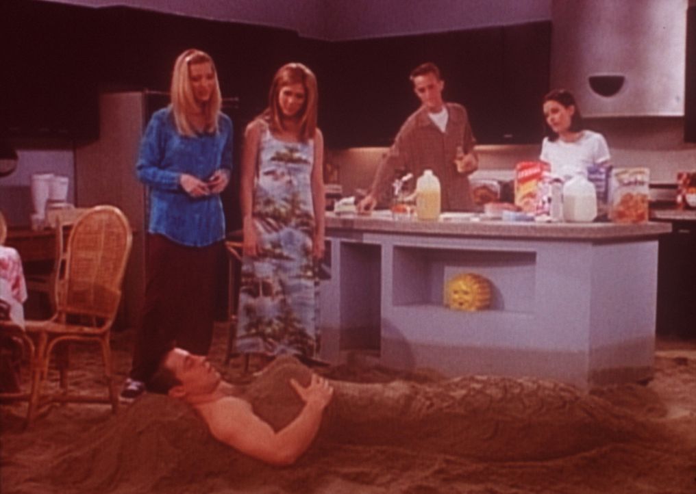 Damit Joey (Matt LeBlanc, vorne) es ein bisschen wärmer hat, haben ihn seine Freunde mit Sand eingebuddelt. - Bildquelle: TM+  2000 WARNER BROS.