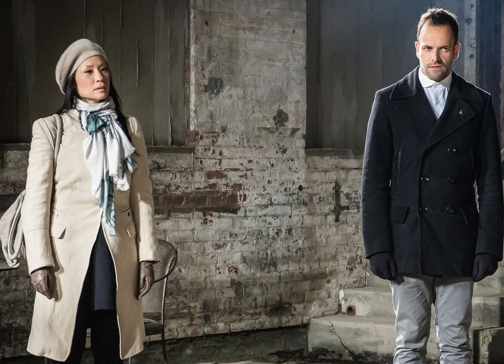 Holmes (Jonny Lee Miller, r.) und Watson (Lucy Liu, l.) statten Moriarty einen Besuch im Gefängnis ab. Dabei stellen sie fest, dass sie dort ein zie... - Bildquelle: CBS Television