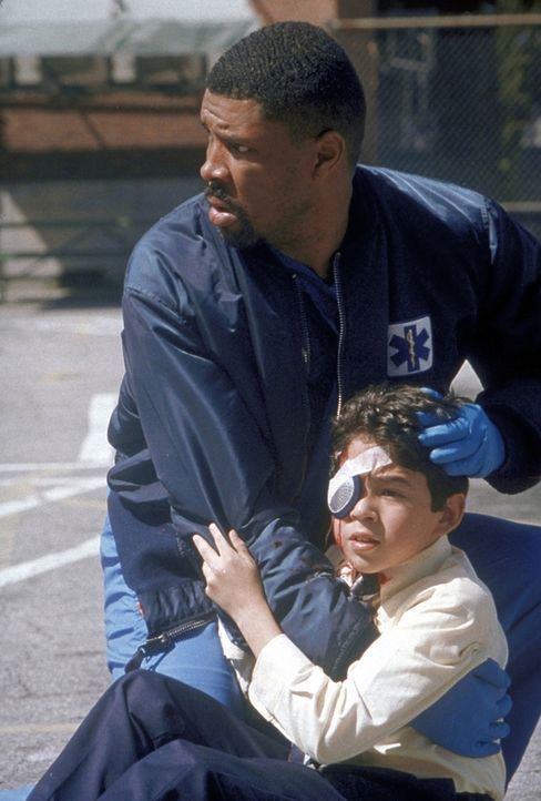 Benton (Eric La Salle, l.) hilft einem kleinen Jungen, der am Auge schwer verletzt ist. - Bildquelle: TM+  2000 WARNER BROS.