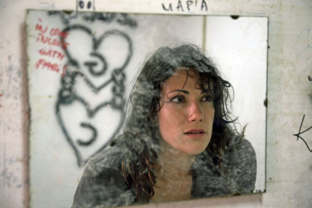 Claudia (Bettina Zimmermann) erstarrt vor Schreck, als sie im Spiegel einer maroden Tankstelle die Initialen C und G entdeckt. - Bildquelle: Sat.1