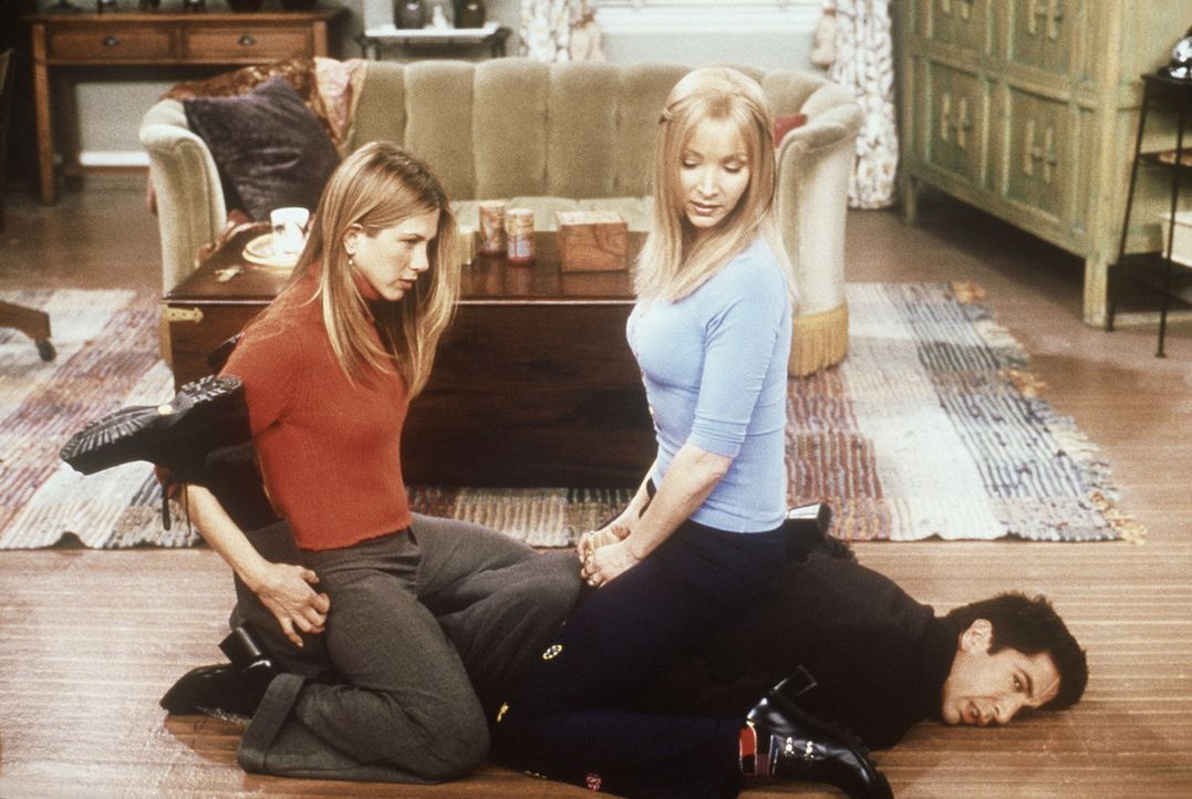 Der am Boden liegende Ross (David Schwimmer, unten) erklärt Phoebe (Lisa Kudrow, r.) und Rachel (Jennifer Aniston, l.), dass die Kunst der Selbstve... - Bildquelle: TM+  2000 WARNER BROS.