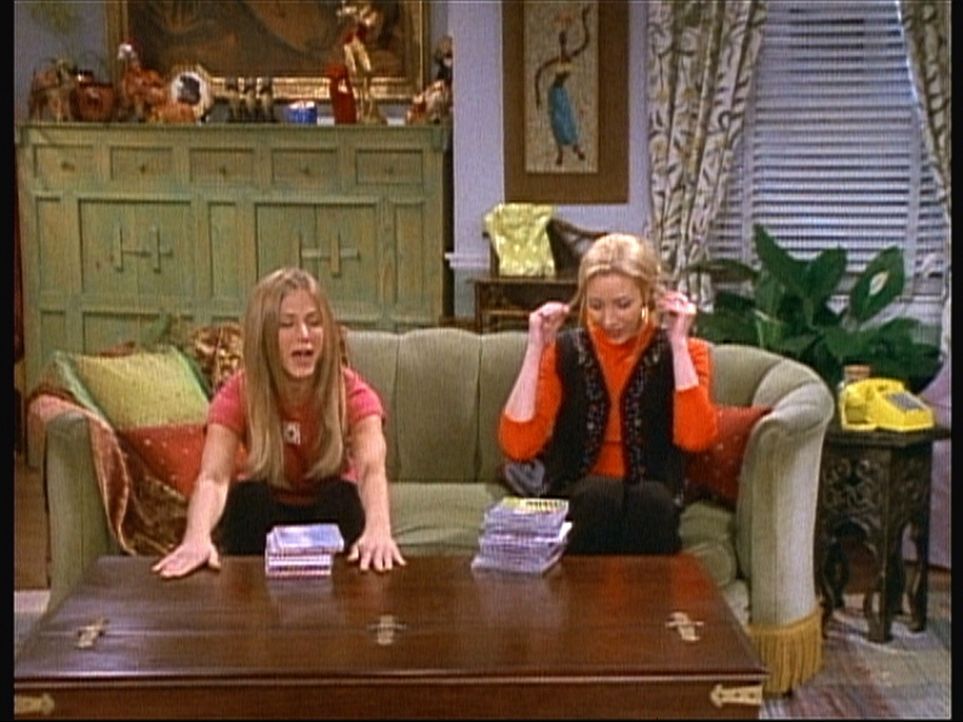 Rachel (Jennifer Aniston, l.) versucht, Phoebe (Lisa Kudrow, r.) den neuen Tisch schmackhaft zu machen. - Bildquelle: TM+  2000 WARNER BROS.